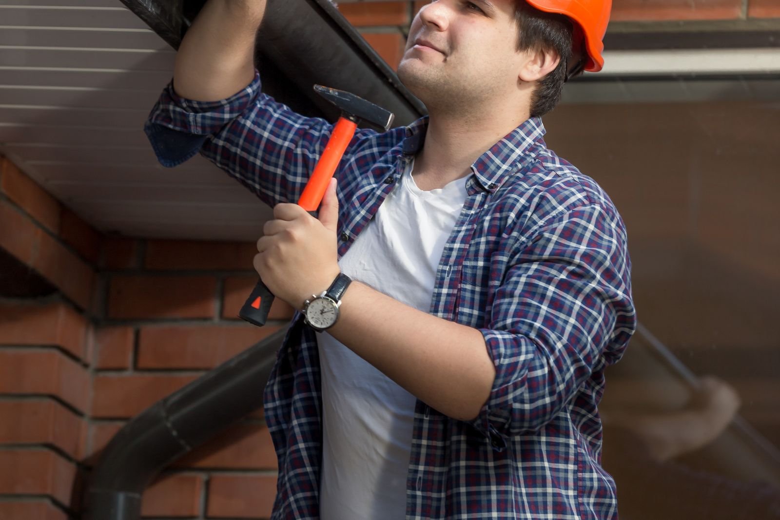 Gutter repair work on the eaves of a brick home